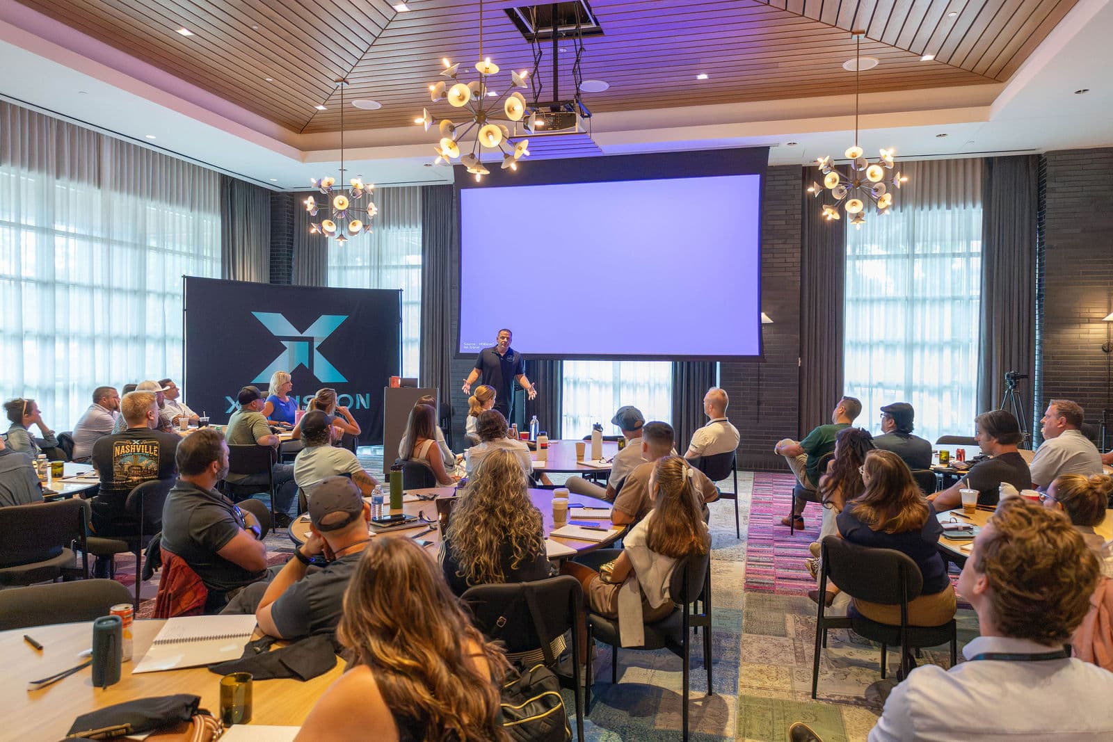 Wide room shot showing the full intimate setting with chandelier